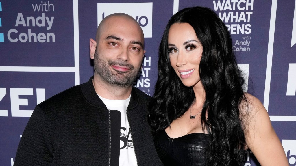 John Fuda and Rachel Fuda wearing black and posing together backstage at Watch What Happens Live