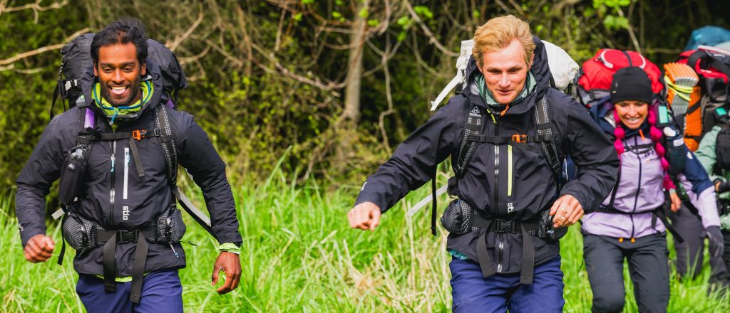 Oliver Dev, Spencer "Corry" Jones, and Ashley Paulson running through a grassy field in the first episode of Race to Survive: New Zealand