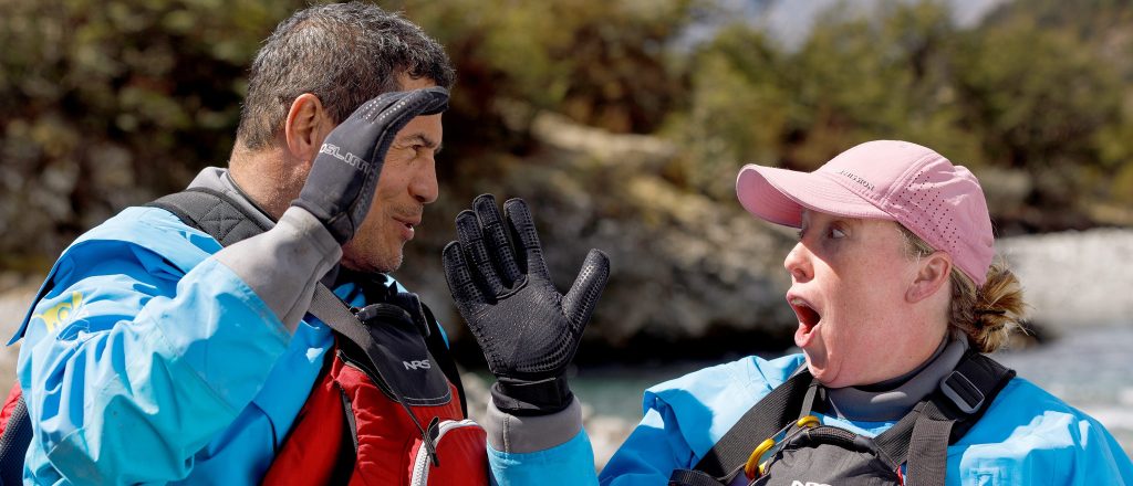 Heather and Emilio from Race to Survive: New Zealand doing a high five with excited expressions on their face.