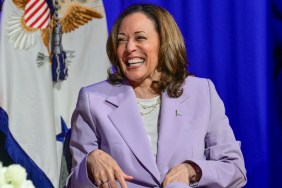 Kamala Harris wearing a lavender suit and laughing