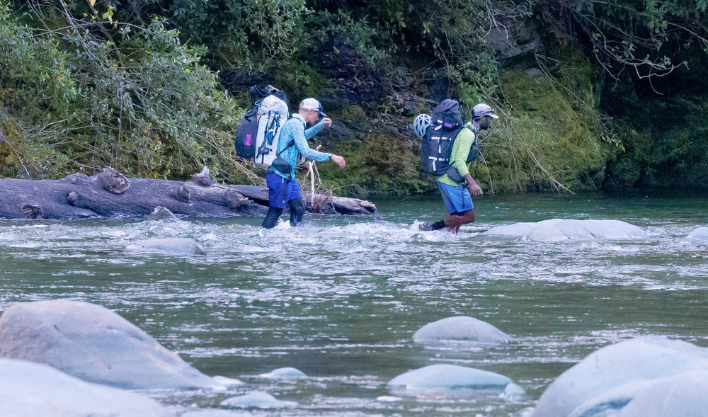 Oliver and Corry walking through water on Race to Survive: New Zealand