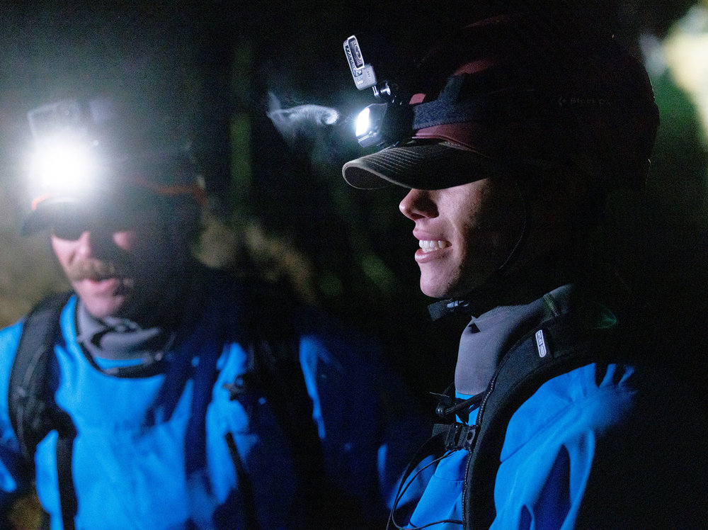 Ryan and Bronson in a cave on Race to Survive; New Zealand, wearing blue jumpsuits and helmets with lights attached to them