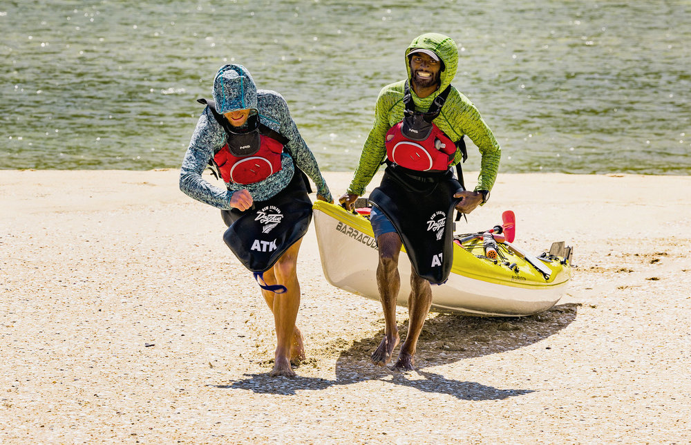 Spencer "Corry" Jones and Oliver Dev pulling a raft on shore in Race to Survive: New Zealand