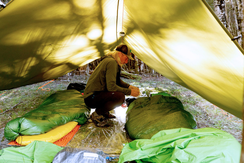 Creighton Baird crouching inside of a tent on Race to Survive: New Zealand 