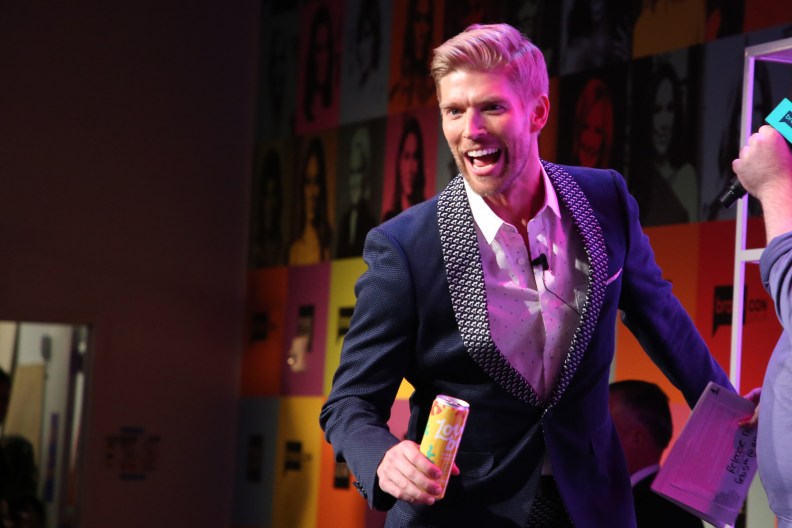 Kyle Cooke holding a can of Loverboy and smiling