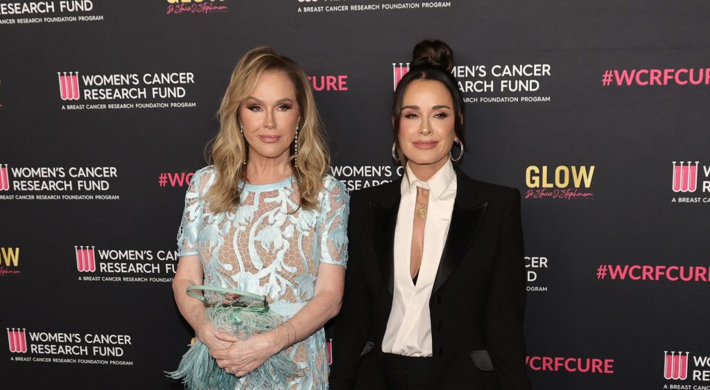 Kathy Hilton in a blue dress posing with Kyle Richards who is wearing a black suit