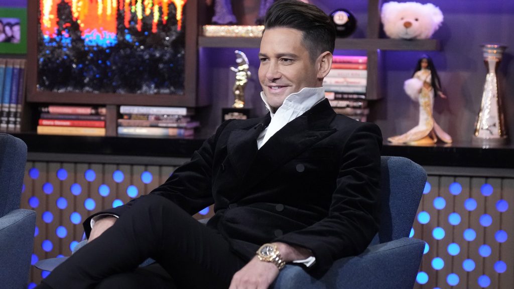 Josh Flagg wearing a suit with a high collar on WWHL.