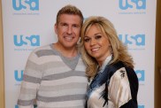 Todd and Julie Chrisley standing in front of a USA Network backdrop