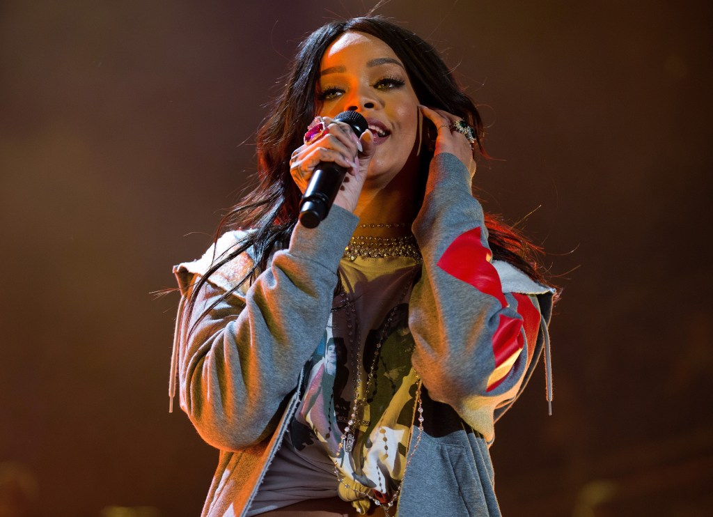 Rihanna singing while holding a microphone.