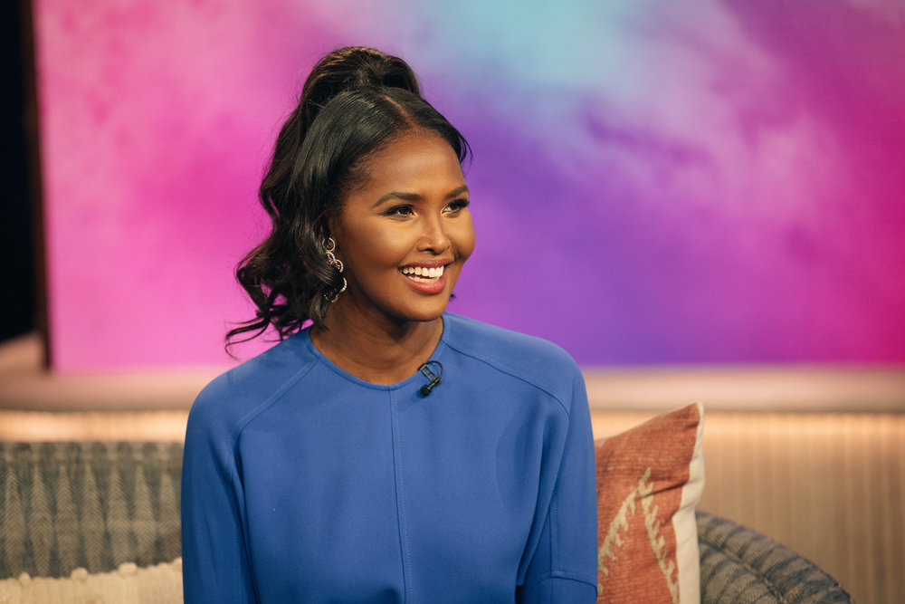 Real Housewives of New York star Ubah Hassan in a blue dress smiling. 