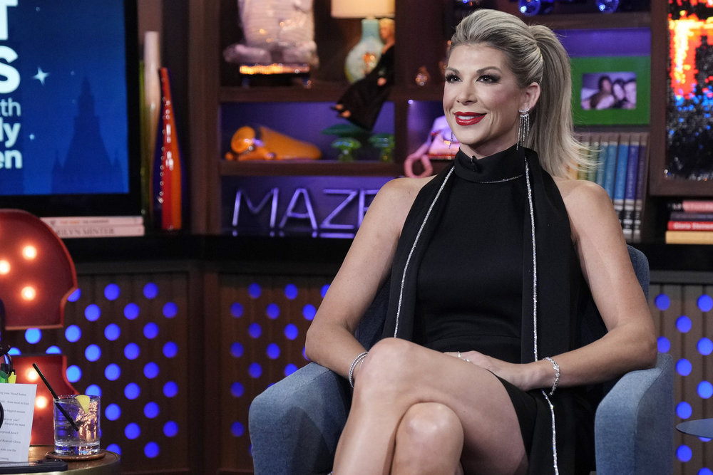 Alexis Bellino looks stunning in a black dress with a red lip on WWHL.