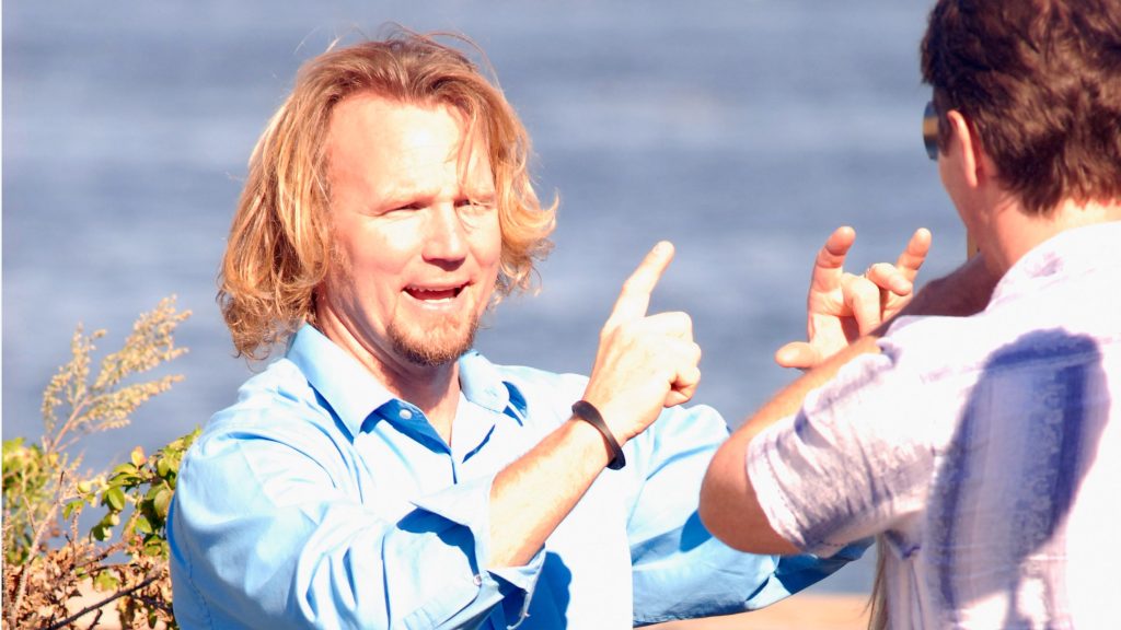 Sister Wives star Kody Brown with the wind in his hair and his hands in the air.