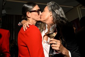 Jenna Lyons in a red blazer kissing Cass Bird who is holding a glass of wine and wearing black