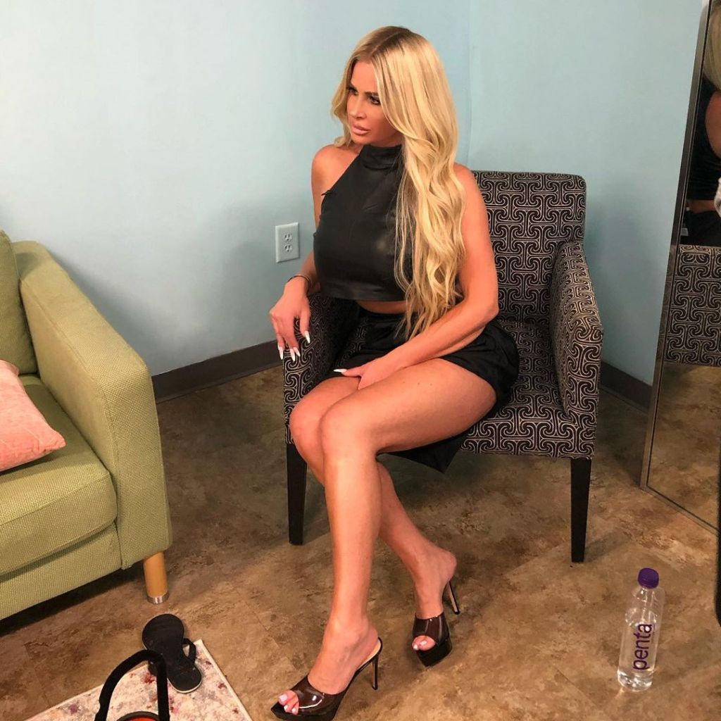 Kim Zolciak sitting on a chair, facing away from the camera