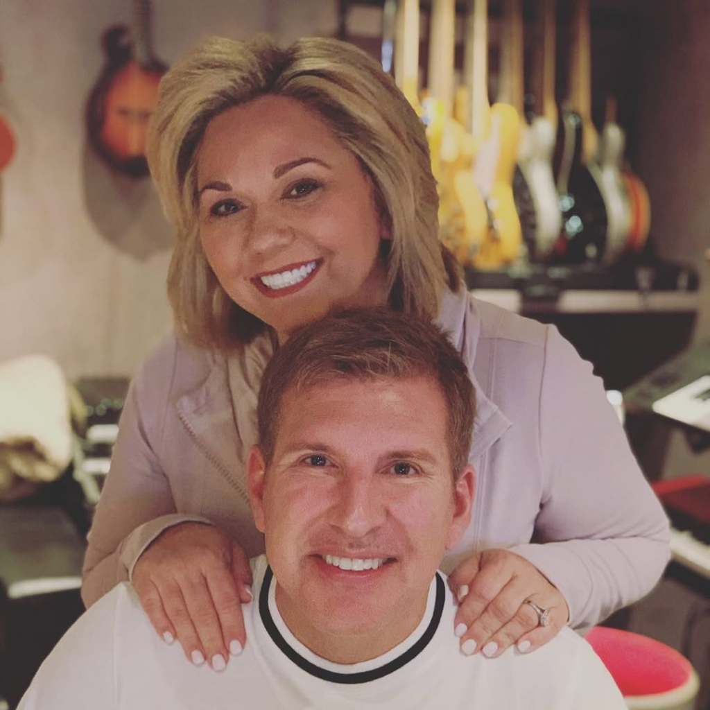 Julie Chrisley with her hands on Todd Chrisley's shoulders 