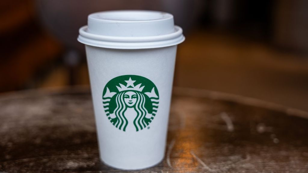 In this photo illustration, a Starbucks coffee cup sits on a table at a store in Manhattan on January 30, 2024 in New York City. The global coffee chain officially introduced its extra virgin olive oil-infused drinks on Tuesday. Named Oleato, the drinks debuted in Italy in February 2023 and arrive in stores on the same day Starbucks will report fourth-quarter earnings.