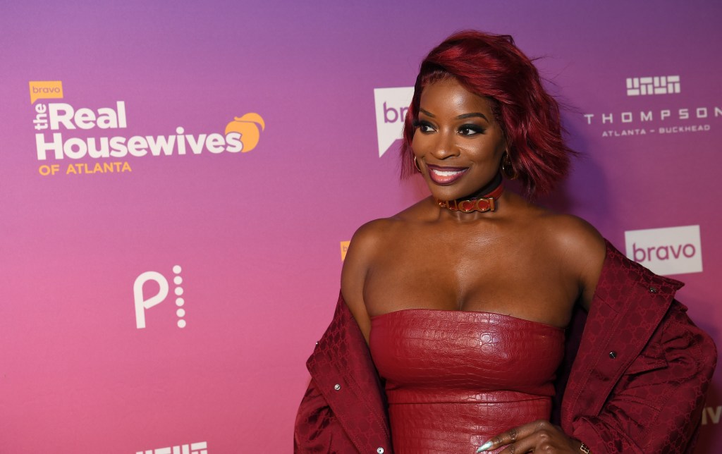 Shamea Morton at a RHOA premiere event wearing a red dress and red hair